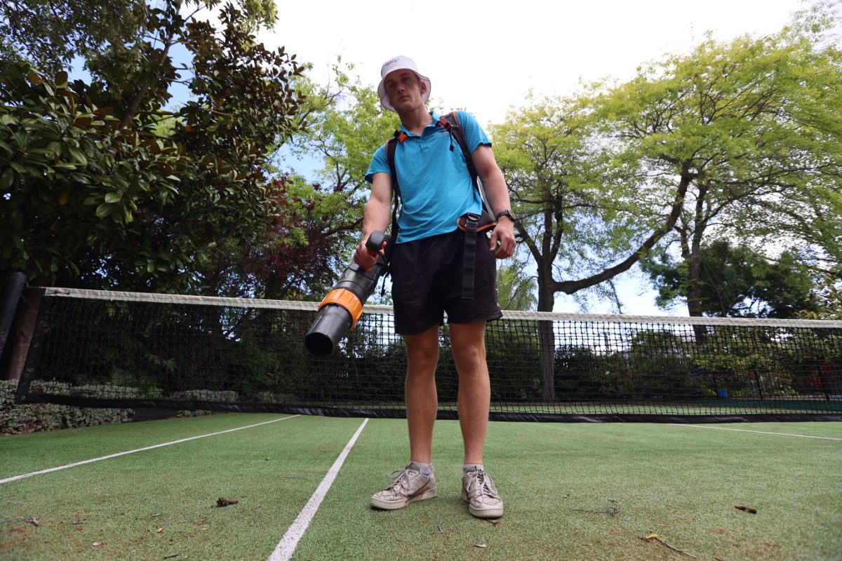 CourtClean crew member clearing a court with a cordless blower